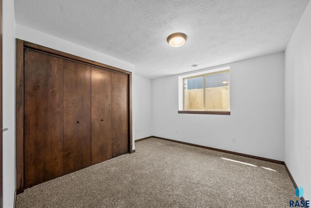 525 Quartzite Ave, Tea, SD 57064 - unfurnished bedroom with carpet, a closet, baseboards, and a textured ceiling