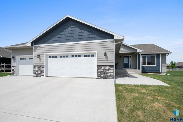 525 Quartzite Ave, Tea, SD 57064 - view of front of property featuring an attached garage, concrete driveway, a front yard, and stone siding