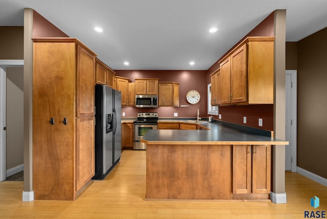 5516 S Tierney Pl, Sioux Falls, SD 57108 - kitchen featuring appliances with stainless steel finishes, a peninsula, a sink, light wood-style flooring, and recessed lighting