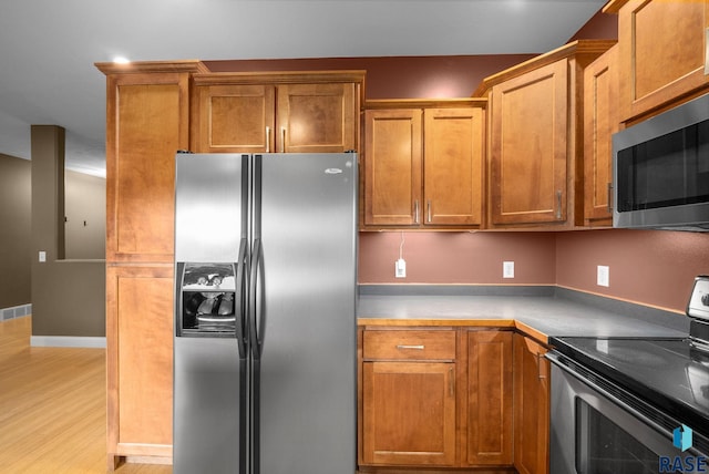 5516 S Tierney Pl, Sioux Falls, SD 57108 - kitchen featuring stainless steel appliances, light wood-style flooring, and brown cabinetry