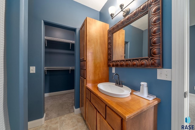 5516 S Tierney Pl, Sioux Falls, SD 57108 - bathroom featuring a walk in closet, vanity, baseboards, and tile patterned floors