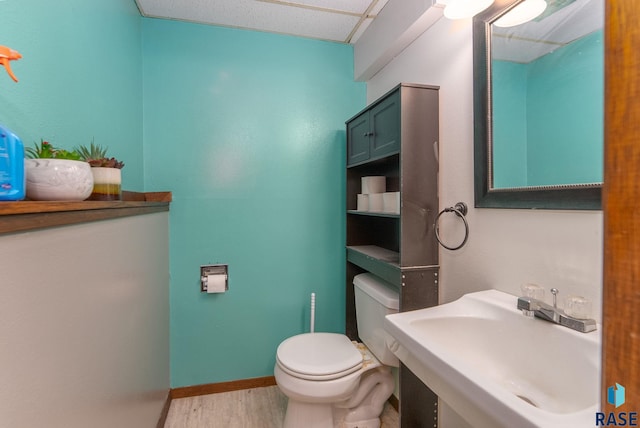 316 S Norbeck St, Vermillion, SD 57069 - bathroom with a sink, wood finished floors, toilet, and baseboards