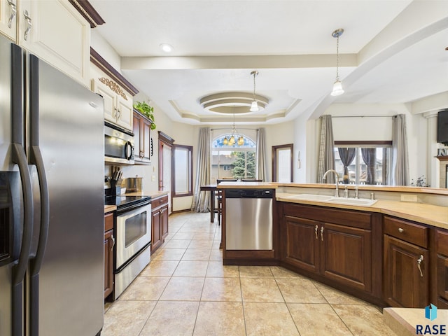 8113 S Copper Ridge Rd, Sioux Falls, SD 57108 - kitchen featuring appliances with stainless steel finishes, a sink, a tray ceiling, light countertops, and pendant lighting
