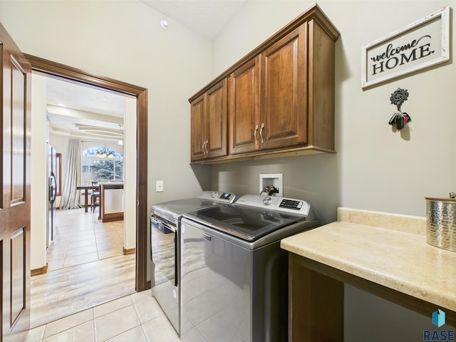 8113 S Copper Ridge Rd, Sioux Falls, SD 57108 - laundry area with cabinet space, independent washer and dryer, light tile patterned floors, and baseboards