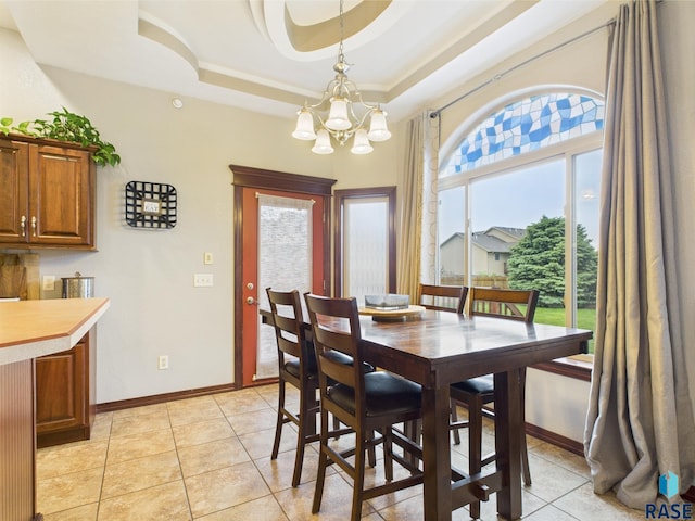 8113 S Copper Ridge Rd, Sioux Falls, SD 57108 - dining room with a chandelier, light tile patterned flooring, a tray ceiling, and baseboards
