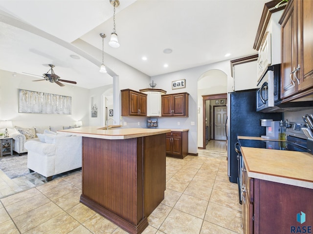 8113 S Copper Ridge Rd, Sioux Falls, SD 57108 - kitchen featuring arched walkways, stainless steel appliances, open floor plan, light countertops, and ceiling fan
