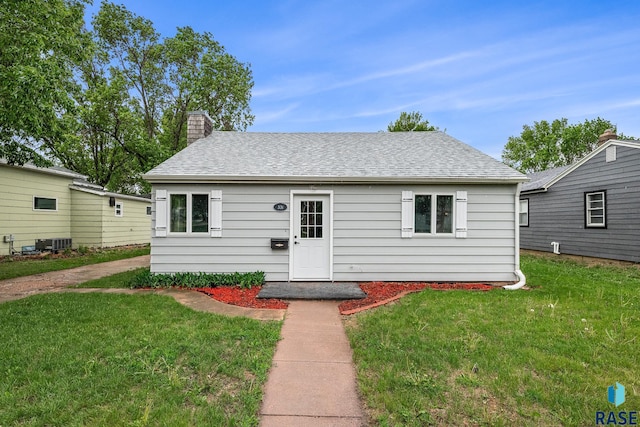 331 E Norton Ave, Salem, SD 57058 - view of front facade featuring a front lawn, roof with shingles, central AC, and a chimney