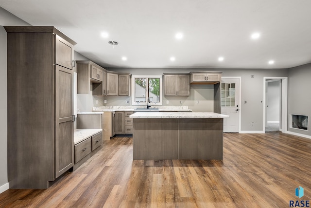 331 E Norton Ave, Salem, SD 57058 - kitchen with a center island, recessed lighting, baseboards, wood finished floors, and a sink