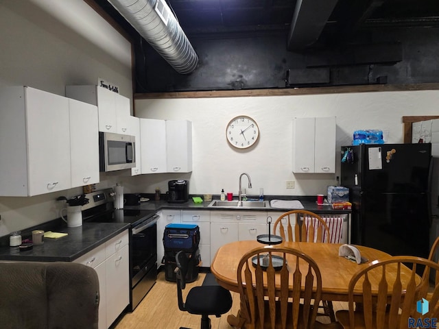 231 S 5th St, Menno, SD 57045 - kitchen featuring appliances with stainless steel finishes, a sink, dark countertops, and white cabinetry