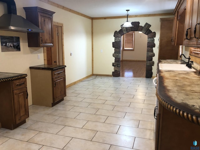 231 S 5th St, Menno, SD 57045 - kitchen with wall chimney range hood, a sink, dark brown cabinetry, baseboards, and pendant lighting
