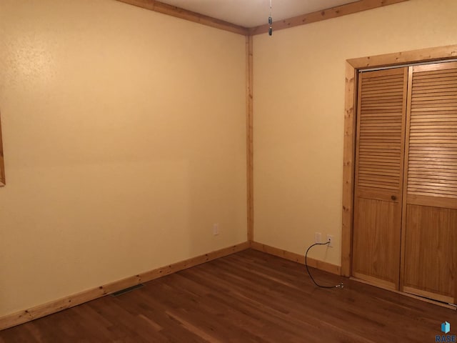 231 S 5th St, Menno, SD 57045 - unfurnished bedroom with dark wood-style floors, a closet, and baseboards