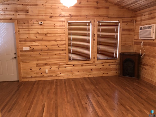 231 S 5th St, Menno, SD 57045 - unfurnished living room with wooden walls, a wall unit AC, vaulted ceiling, and hardwood / wood-style flooring