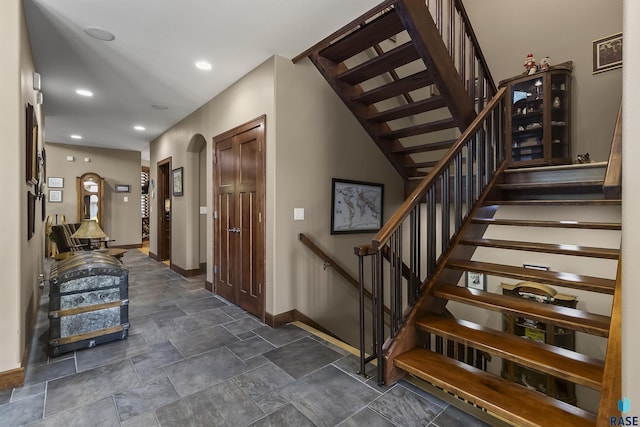 2502 S Big Timber Pl, Sioux Falls, SD 57105 - stairway with baseboards, stone finish flooring, arched walkways, and recessed lighting