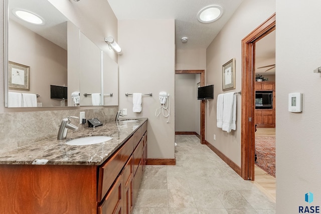 2502 S Big Timber Pl, Sioux Falls, SD 57105 - full bathroom with double vanity, tasteful backsplash, baseboards, and tile patterned floors