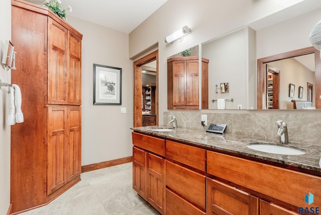 2502 S Big Timber Pl, Sioux Falls, SD 57105 - bathroom with baseboards, double vanity, tile patterned flooring, and backsplash