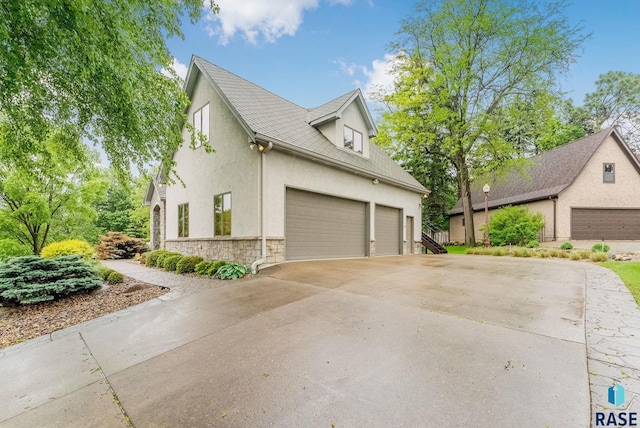 2502 S Big Timber Pl, Sioux Falls, SD 57105 - view of home's exterior featuring stone siding, stucco siding, a garage, and concrete driveway