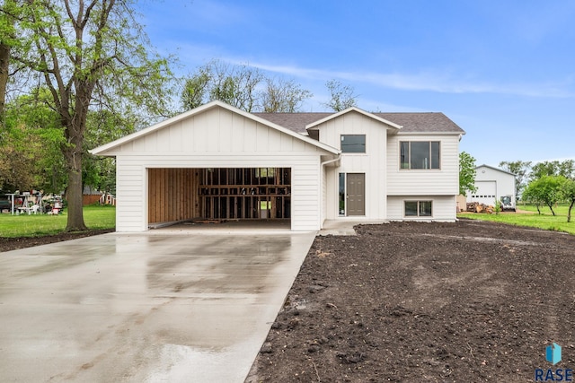 851 N 4th Ave, Canistota, SD 57012 - view of front of property with board and batten siding, concrete driveway, a garage, and roof with shingles