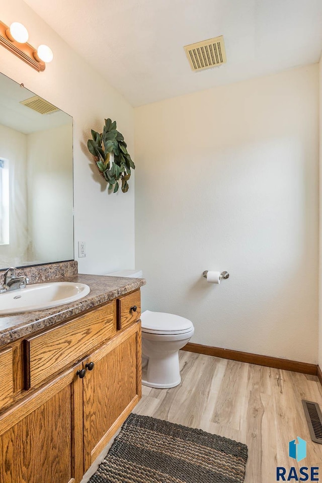 1808 S Mulberry Ave Unit D, Brandon, SD 57005 - half bathroom with toilet, wood finished floors, vanity, and baseboards