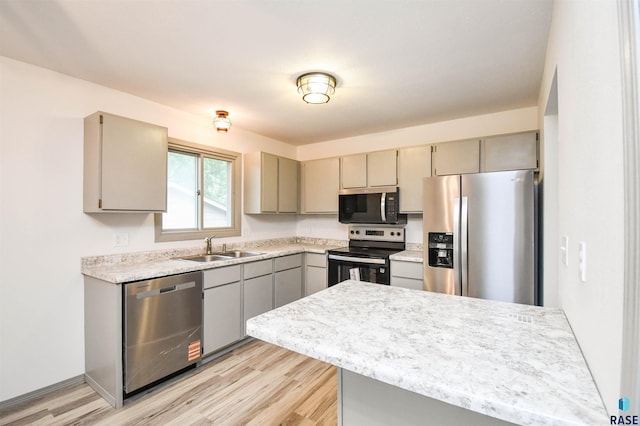 4301 E 28th St, Sioux Falls, SD 57103 - kitchen featuring appliances with stainless steel finishes, gray cabinets, a sink, and light wood-style floors