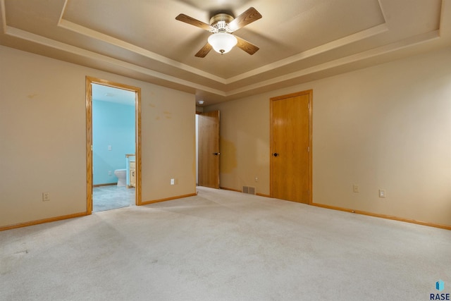 6700 W Snowberry Cir, Sioux Falls, SD 57106 - spare room featuring a raised ceiling, light colored carpet, a ceiling fan, and baseboards