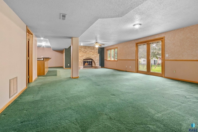 6700 W Snowberry Cir, Sioux Falls, SD 57106 - unfurnished living room featuring a fireplace, baseboards, a textured ceiling, ceiling fan, and carpet