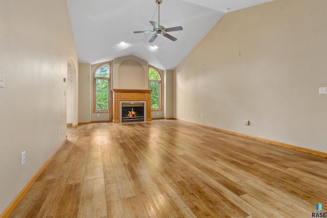 6700 W Snowberry Cir, Sioux Falls, SD 57106 - unfurnished living room with light wood-type flooring, lofted ceiling, ceiling fan, arched walkways, and baseboards