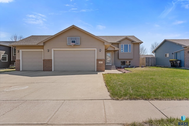 7005 W 65th St, Sioux Falls, SD 57106 - split level home featuring brick siding, a garage, and concrete driveway