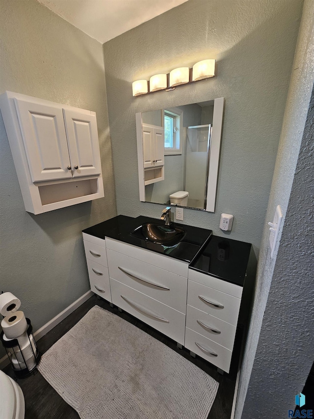 511 N 3rd St, Emery, SD 57332 - full bathroom featuring a shower stall, a textured wall, toilet, vanity, and baseboards