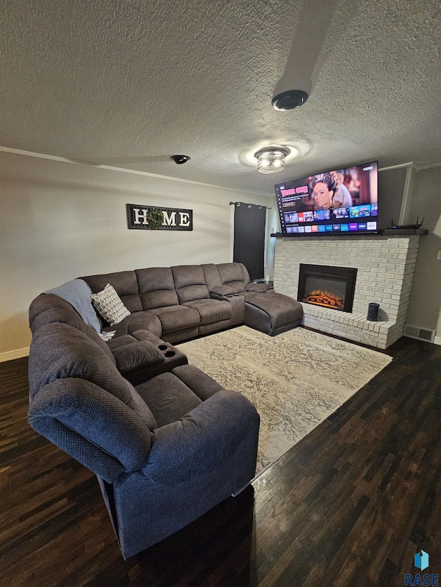 511 N 3rd St, Emery, SD 57332 - living room featuring wood finished floors, a fireplace, baseboards, and a textured ceiling