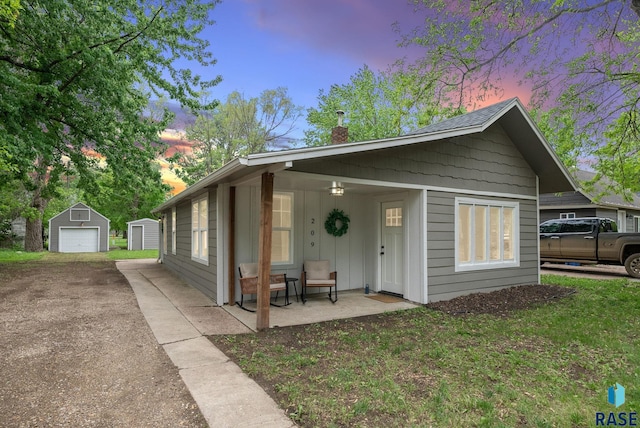 209 E Elm St, Harrisburg, SD 57032 - view of front of house with a detached garage, an outbuilding, a chimney, driveway, and board and batten siding