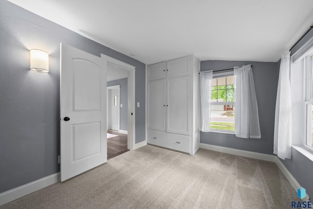 209 E Elm St, Harrisburg, SD 57032 - unfurnished bedroom with carpet, vaulted ceiling, baseboards, and a closet