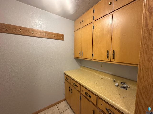 800 N Poplar St, Bridgewater, SD 57319 - kitchen with light countertops, a textured wall, light tile patterned floors, and baseboards