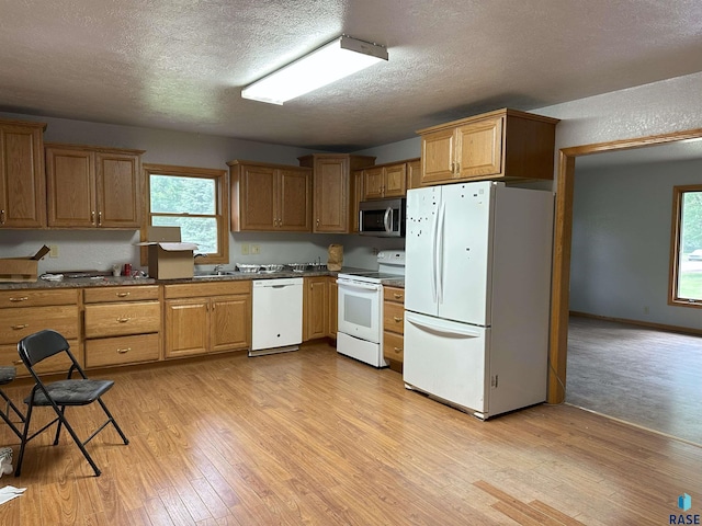 800 N Poplar St, Bridgewater, SD 57319 - kitchen featuring white appliances, light wood-style floors, a textured ceiling, plenty of natural light, and dark countertops