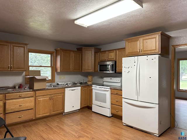 800 N Poplar St, Bridgewater, SD 57319 - kitchen featuring white appliances, dark countertops, light wood finished floors, a textured ceiling, and plenty of natural light