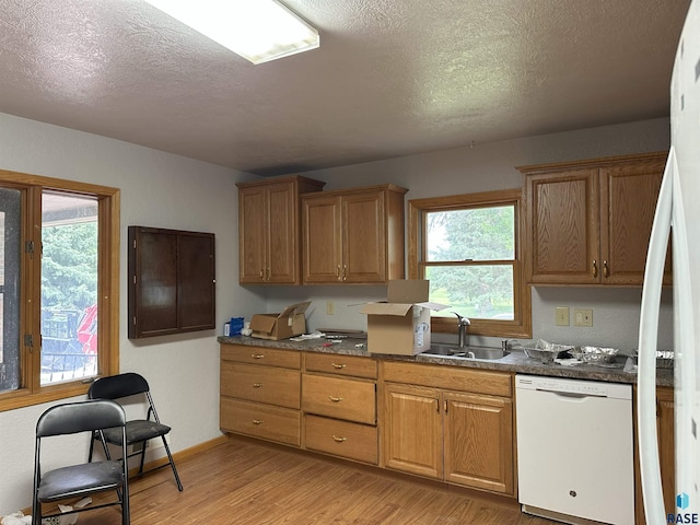 800 N Poplar St, Bridgewater, SD 57319 - kitchen featuring dishwasher, a sink, light wood-style floors, a textured ceiling, and brown cabinetry