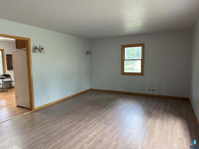800 N Poplar St, Bridgewater, SD 57319 - spare room with wood finished floors, a textured ceiling, and baseboards