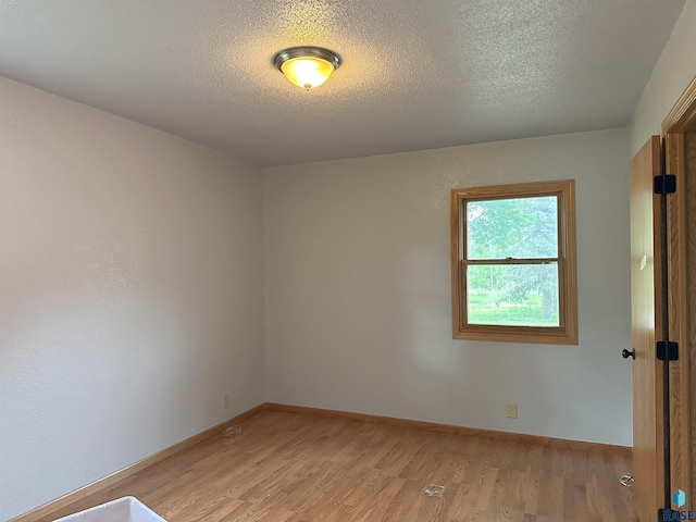 800 N Poplar St, Bridgewater, SD 57319 - empty room featuring light wood-style floors, a textured ceiling, and baseboards