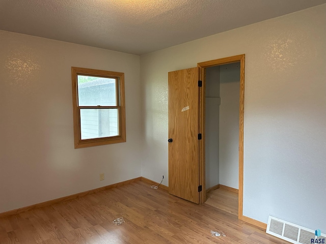 800 N Poplar St, Bridgewater, SD 57319 - unfurnished bedroom with light wood-style floors, a walk in closet, baseboards, and a closet