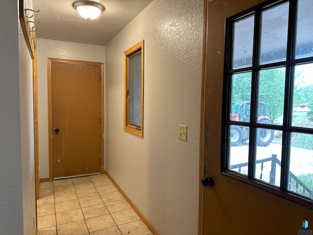 800 N Poplar St, Bridgewater, SD 57319 - hall with a textured wall, light tile patterned flooring, and baseboards