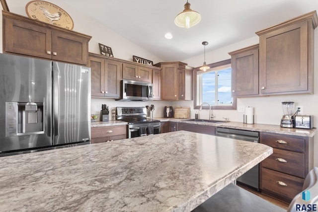 7305 W Jacob Cir, Sioux Falls, SD 57106 - kitchen featuring stainless steel appliances, a sink, vaulted ceiling, decorative light fixtures, and light stone counters