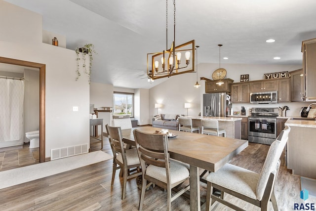 7305 W Jacob Cir, Sioux Falls, SD 57106 - dining room featuring vaulted ceiling, a chandelier, dark wood finished floors, baseboards, and recessed lighting