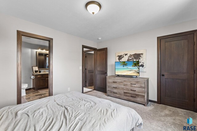 7305 W Jacob Cir, Sioux Falls, SD 57106 - bedroom with light carpet, baseboards, and connected bathroom