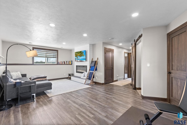 7305 W Jacob Cir, Sioux Falls, SD 57106 - living area featuring a barn door, baseboards, recessed lighting, wood finished floors, and a fireplace