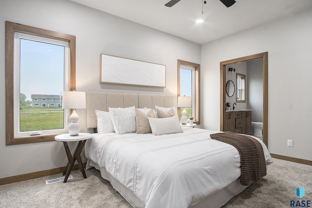 501 S Huckleberry Trl, Harrisburg, SD 57032 - bedroom with carpet floors, baseboards, connected bathroom, a sink, and a ceiling fan