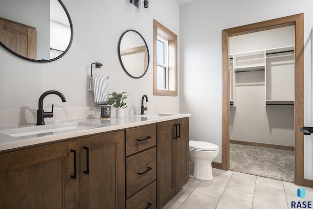 501 S Huckleberry Trl, Harrisburg, SD 57032 - full bath featuring double vanity, toilet, a spacious closet, and tile patterned flooring