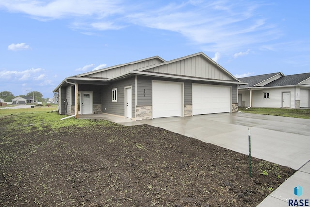 501 S Huckleberry Trl, Harrisburg, SD 57032 - view of front facade with an attached garage, concrete driveway, board and batten siding, and stone siding
