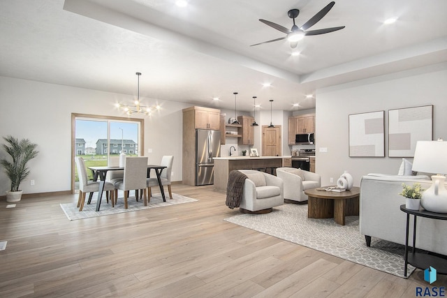 501 S Huckleberry Trl, Harrisburg, SD 57032 - living room featuring a raised ceiling, a chandelier, light wood-type flooring, ceiling fan, and recessed lighting