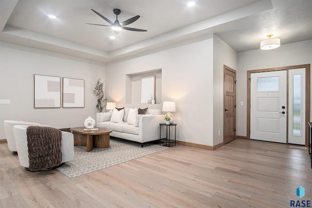 501 S Huckleberry Trl, Harrisburg, SD 57032 - living area featuring a ceiling fan, light wood-type flooring, baseboards, and a raised ceiling