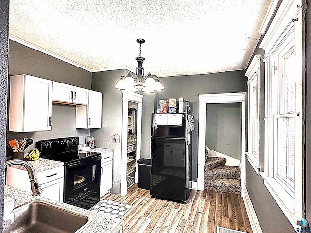 816 W 4th St, Canton, SD 57013 - kitchen with black appliances, a sink, light countertops, a chandelier, and white cabinets