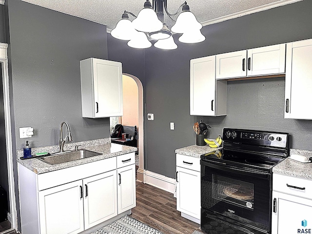 816 W 4th St, Canton, SD 57013 - kitchen with black electric range, a sink, a chandelier, white cabinets, and arched walkways